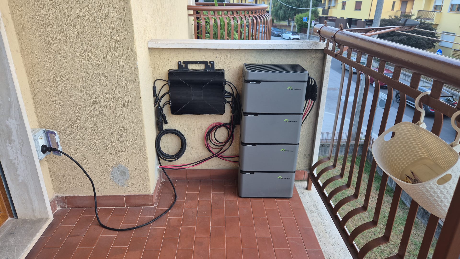 Italienischer Wohnungsbalkon mit vier gestapelten LIONSHEE Batteriemodulen, wandmontierter Einheit und Kabelf&uuml;hrung zur Steckdose